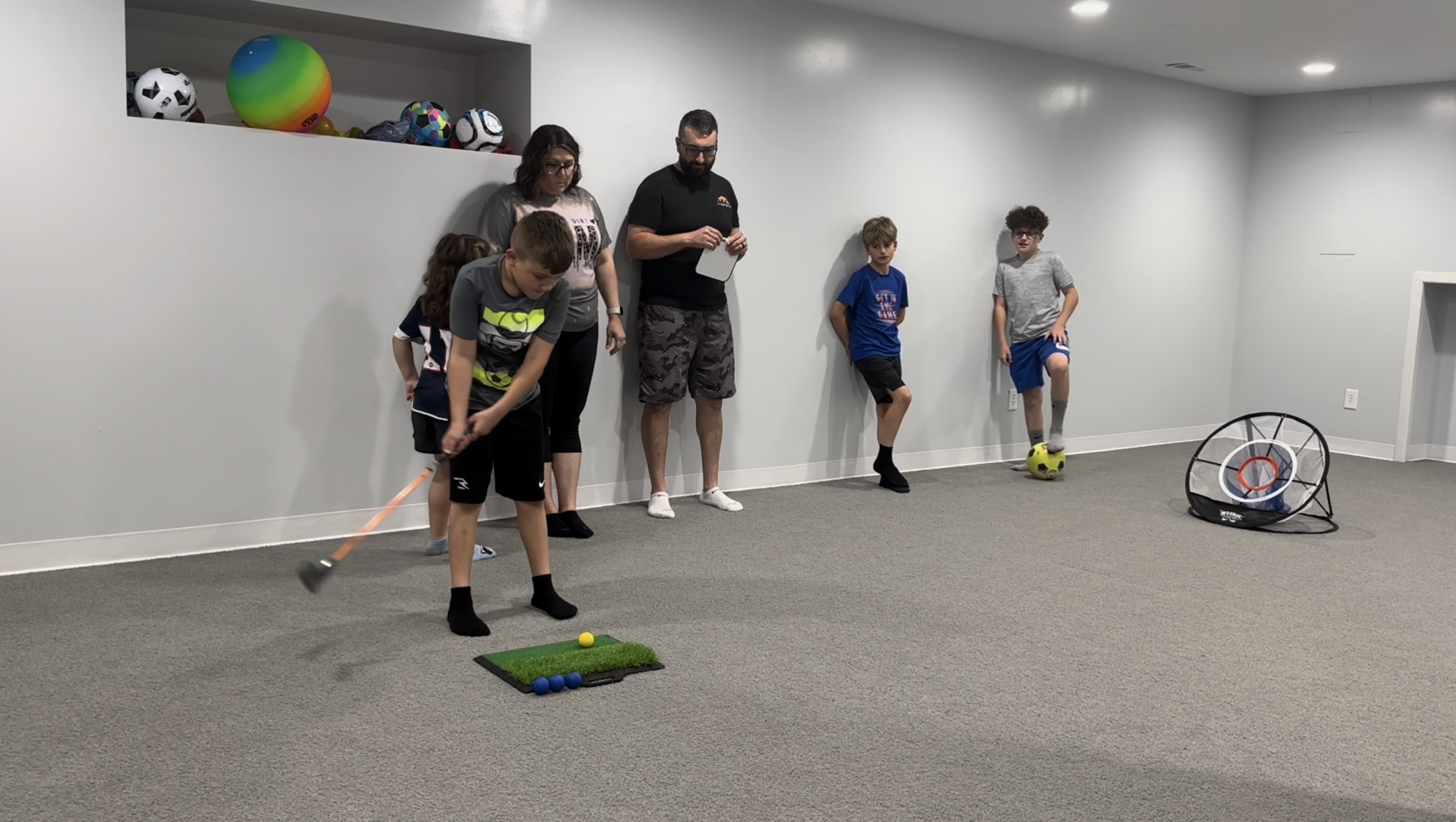Child practicing hand-eye coordination with Wedge Master golf training set, improving motor skills and focus through fun indoor play.