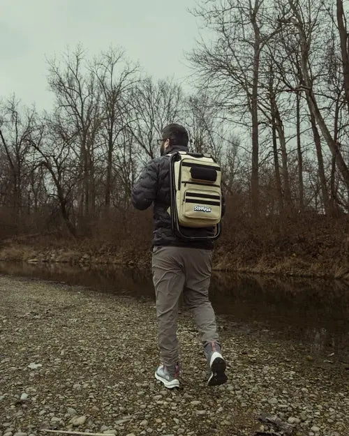 Adult walking in a creek wearing a tan StoolPak
