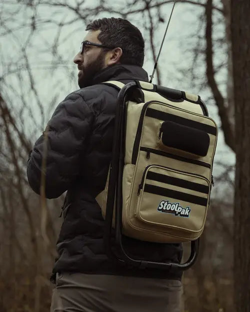 Adult wearing a tan StoolPak at a creek